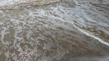 Güzel manzara - turkuaz renkli deniz suyu, kum, gökyüzü. Dalgalar kıyıya vuruyor. Plaj ve Su Sıçratan Dalgalar