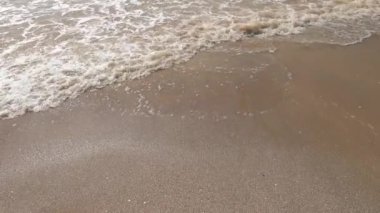 Deniz kumsalı, mavi gökyüzü, kum ve güneş. Yazın dalgalı deniz kıyıları