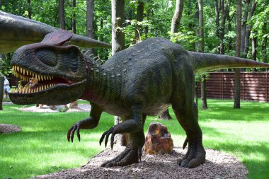 DINO PARK, KHARKOV - 8 AĞUSTOS 2021: Parktaki krilophosaurus Dinozor heykeli görüntüsü. Tarih öncesi hayvanlar milyonlarca yıl önce dünyada yaşamış..