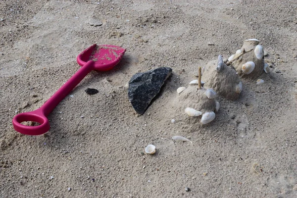 Sandkastenspielzeug Aus Plastik Sand Sandburg Mit Muscheln Geschmückt Plastikschaufel Auf — Stockfoto