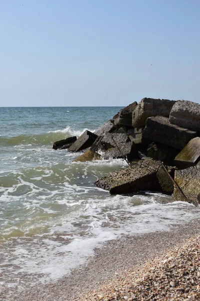 海岸巨石上的绿松石海破浪形成了浓密的白色泡沫 晴朗的蓝天 白浪在沙滩上冲破了海上岩石的缝隙 — 图库照片