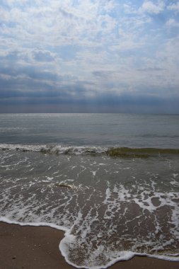 Güzel manzara - turkuaz renkli deniz suyu, kum, gökyüzü. Dalgalar kıyıya vuruyor. Plaj ve Su Sıçratan Dalgalar
