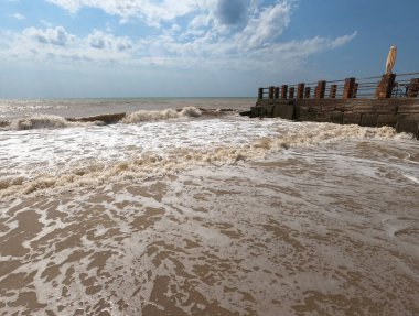 Rıhtım, fırtınalı bir günde kıyıdaki deniz dalgalarını kesiyor..