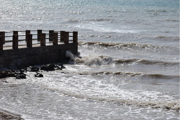 大きな海の波が桟橋に打ち寄せる 桟橋は嵐の晴れた日に海岸から海の波をカットします — ストック写真