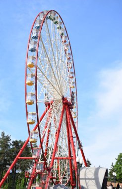Şehir parkında mavi gökyüzüne karşı dönmedolap ve fotokopi alanı.