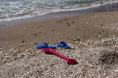 Plaj arka planı parmak arası terlik ve plastik kürek. tatil ve tatil kavramı.