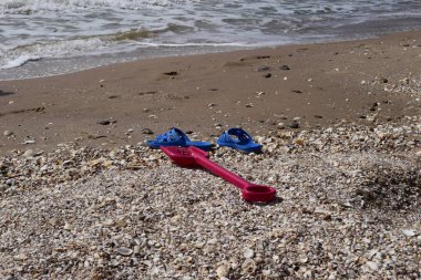 Plaj arka planı parmak arası terlik ve plastik kürek. tatil ve tatil kavramı.