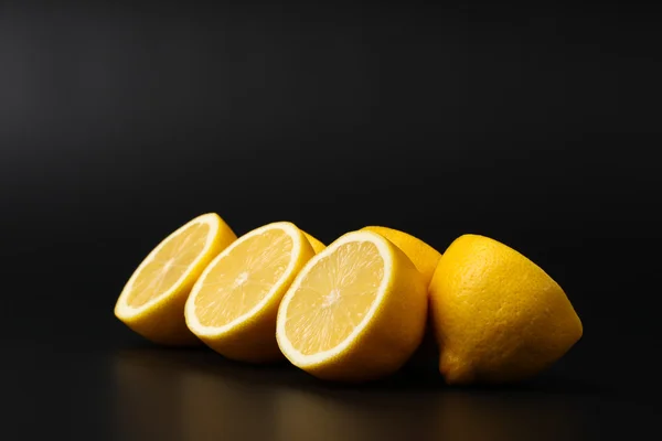 Вирізати лимони на чорному тлі — стокове фото