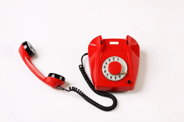 Teléfono giratorio rojo fuera de gancho sobre fondo blanco — Foto de Stock