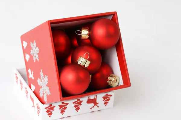 กล่องสีแดงที่มีการตกแต่งคริสต์มาสบนพื้นหลังสีขาว — ภาพถ่ายสต็อก