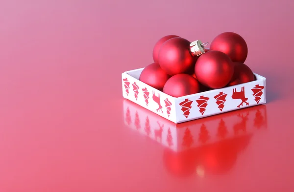 Bolas de Navidad en caja sobre fondo rojo — Foto de Stock