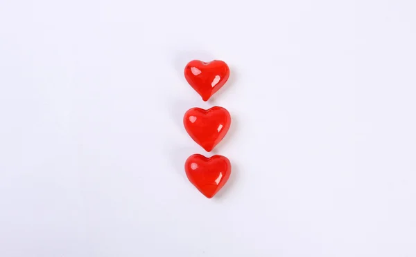 Trzy czerwone szklane serce w wierszu powyżej — Zdjęcie stockowe