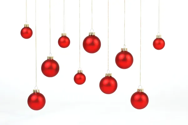 Červený matný vánoční koule zavěšená na zlaté struny na bílém pozadí — Stock fotografie