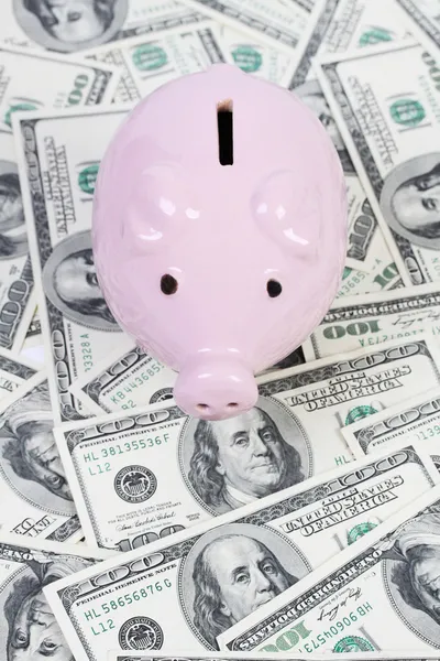 Piggy bank stijl geld doos op de achtergrond met geld Amerikaanse honderd dollar biljetten — Stockfoto