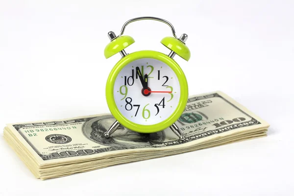 Old alarm clock standing on stack of money american hundred dollar bills on white background — Stock Photo, Image