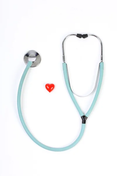 Médecins stéthoscope et un petit coeur rouge sur fond blanc — Photo