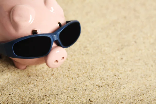 Summer Piggy Bank com óculos de sol em pé na praia — Fotografia de Stock