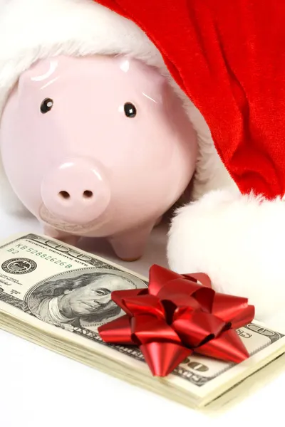 Del av spargris med jultomten hatt och stack pengar amerikanska 100-dollarsedlar med röd rosett på vit bakgrund — Stockfoto