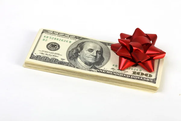 Pila di denaro americano banconote da cento dollari con fiocco rosso su sfondo bianco — Foto Stock