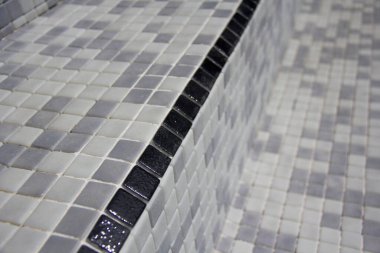 Siyah merdiven kenarlı fayanslar yenilenmiş yüzme havuzuna uygulanır. Yüzme havuzu yenilenmesi sırasında çekilen resimler gruplandırmadan önce.