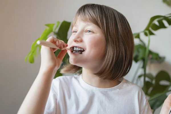 Une fille se brosse les dents avec une brosse à dents écologique et du dentifrice bio. Soins buccodentaires. Protection contre la carie. Routines quotidiennes — Photo