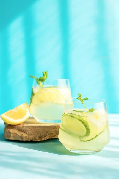 Свежий детоксикационный напиток с огурцом и ломтиками лимона, с мятой в твердых лучах солнца. Летний коктейль. Концепция здорового питания — стоковое фото
