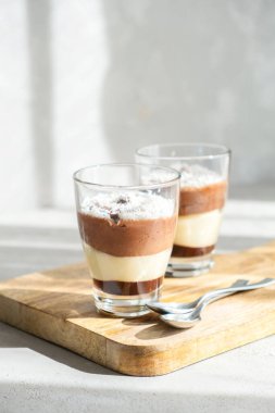 Üç katlı çikolatalı vanilyalı ve kremalı brulee mousse tatlısı, hindistan cevizi gevreğiyle süslenmiş. Kafelerde atıştırmalık ve evde brunch.