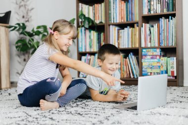 Çocuklar dersleri dizüstü bilgisayardan izler ve online görüşmeler yaparlar. Sosyal medya ve teknolojinin çocuklar tarafından kullanılması. İnternette evde çalış.