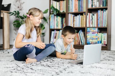 Çocuklar dersleri dizüstü bilgisayardan izler ve online görüşmeler yaparlar. Sosyal medya ve teknolojinin çocuklar tarafından kullanılması. İnternette evde çalış.