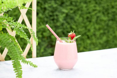 Çilekli muzlu milkshake ya da çilek ve nane yaprağıyla süslenmiş smoothie. Ferahlatıcı yaz meşrubatı. Sağlıklı gıda konsepti