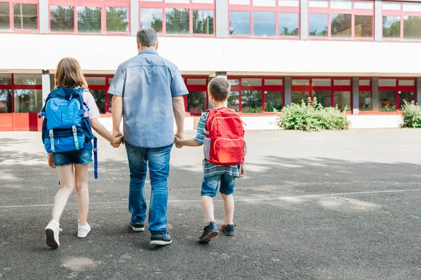 Young Dad Leads His Children Hand Backpacks Backs School Back — Fotografia de Stock