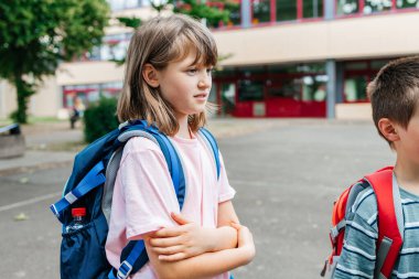 Sırtında sırt çantası olan liseli bir kız okul bahçesinde durup babama veda ediyor. Çocuklar tatilden sonra okula geri dönerler..