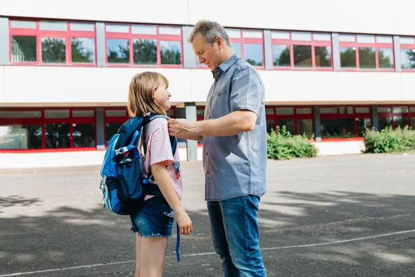 Dad Helps Put Backpack Put Schoolgirl Daughter Girl Smiles Glad — Fotografia de Stock
