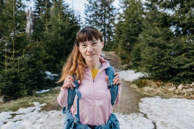 Portrait of a young girl walking in the forest. The girl is engaged in hiking, resting and relaxing enjoying nature