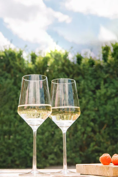 Due Bicchieri Vino Bianco Tavolo Legno Contro Una Siepe Verde — Foto Stock