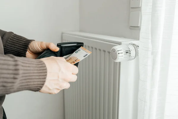 Mensenhanden Houden Een Portemonnee Met Geld Naast Radiatoren Het Concept — Stockfoto