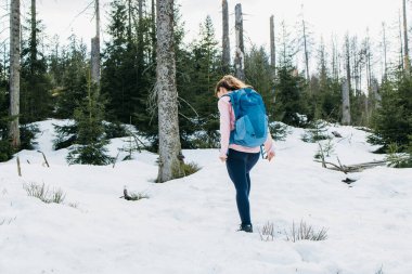 Sırtında spor çantasıyla genç bir kız ormanda yürüyüşe çıkar. Sağlıklı yaşam tarzı, doğayla bütünlük..