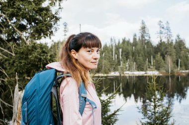Portrait of a young girl walking in the forest. The girl is engaged in hiking, resting and relaxing enjoying nature