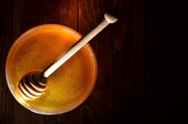 Jar of honey and stick — Stock Photo, Image