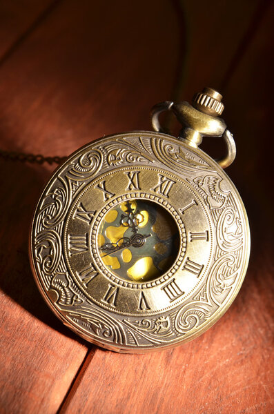 Карманные часы на деревянном фоне
