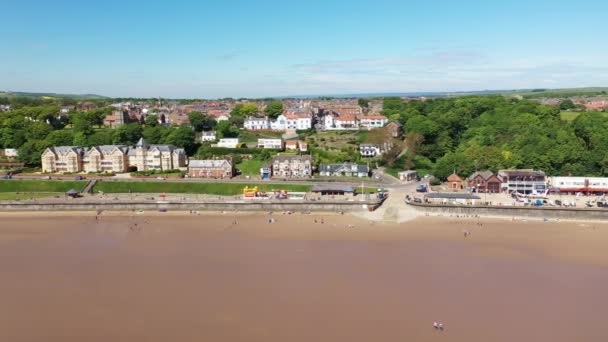 イギリスのフィリーの町のビーチフロントの空中映像は 晴れた夏の日に人々がリラックスしてビーチで楽しんでいることを示しています — ストック動画