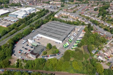 Leeds İngiltere 'deki Bramley kasabasının havadan çekilmiş fotoğrafı, yaz aylarında tren rayları boyunca park etmiş otobüslerle ana otobüs durağını gösteriyor.
