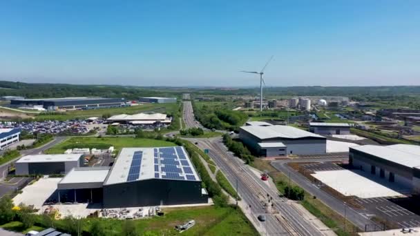 夏時間の暑い晴れた日に英国リーズの町のクロスグリーンの場合地区のノストロップ汚泥処理施設の隣に風力タービン電気エネルギーの作成者の空中映像 — ストック動画