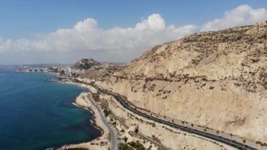 İspanya 'nın Alicante kentindeki çarpıcı plajın havadan çekilmiş görüntüleri. Parlak bir yaz gününde sahil boyunca uzanan dağları, uçurumları ve yolu gösteren bir insansız hava aracı ile çekildi.