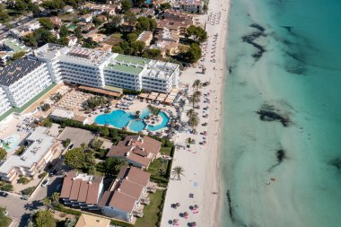 İspanya 'nın Majorca Mallorca adasındaki kumsalın insansız hava aracı fotoğrafı güneşli bir yaz gününde Alcdia köyünün sahilindeki bir tekneyi gösteriyor.