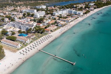 İspanya 'nın Majorca Mallorca adasındaki kumsalın insansız hava aracı fotoğrafı güneşli bir yaz gününde Alcdia köyünün sahilindeki bir tekneyi gösteriyor.