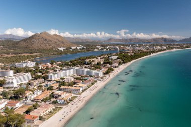 İspanya 'nın Majorca Mallorca adasındaki kumsalın insansız hava aracı fotoğrafı güneşli bir yaz gününde Alcdia köyünün sahilindeki bir tekneyi gösteriyor.