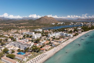 İspanya 'nın Majorca Mallorca adasındaki kumsalın insansız hava aracı fotoğrafı güneşli bir yaz gününde Alcdia köyünün sahilindeki bir tekneyi gösteriyor.