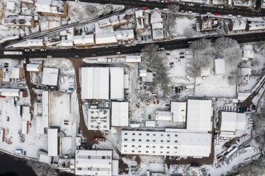 İngiltere, Kirklees, Batı Yorkshire 'daki İngiltere' nin karlı bir gününde, karla kaplı çatıları olan konut evlerini gösteren havadan çekilmiş bir fotoğraf.