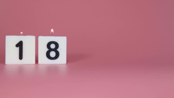 蜡烛一种正方形的蜡烛 表示数字18在粉红的背景下被点燃和吹灭 以庆祝生日或周年纪念日 — 图库视频影像